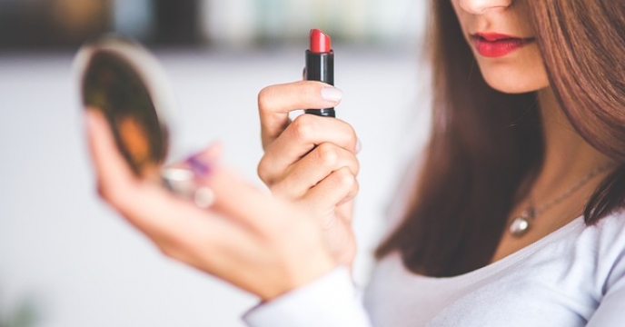 A woman applying lipstick